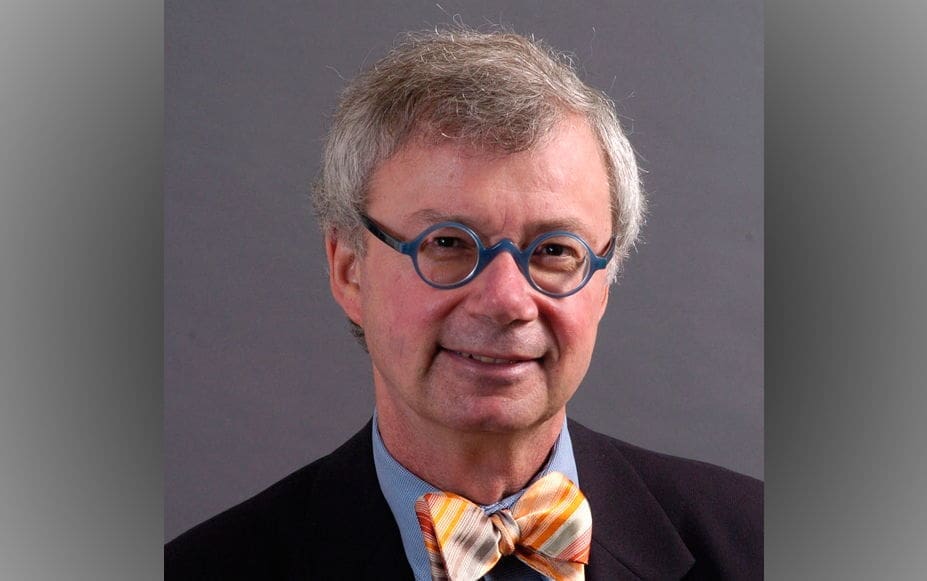 Man in suit with bow tie and glasses.