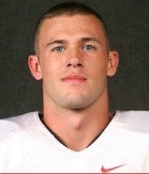 Football player headshot in uniform against dark background.