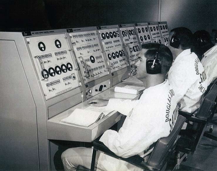 Buddy Davis Technicians monitoring controls in a vintage spacecraft environment.