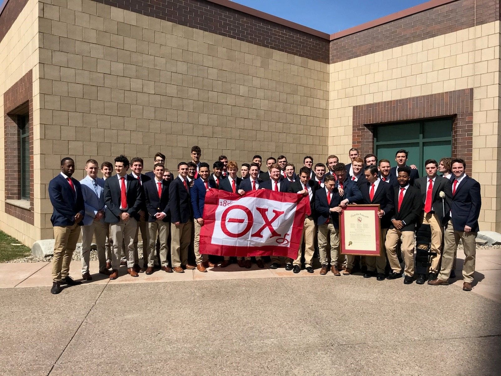 Buffalo reinstall Group photo of fraternity members with flag.