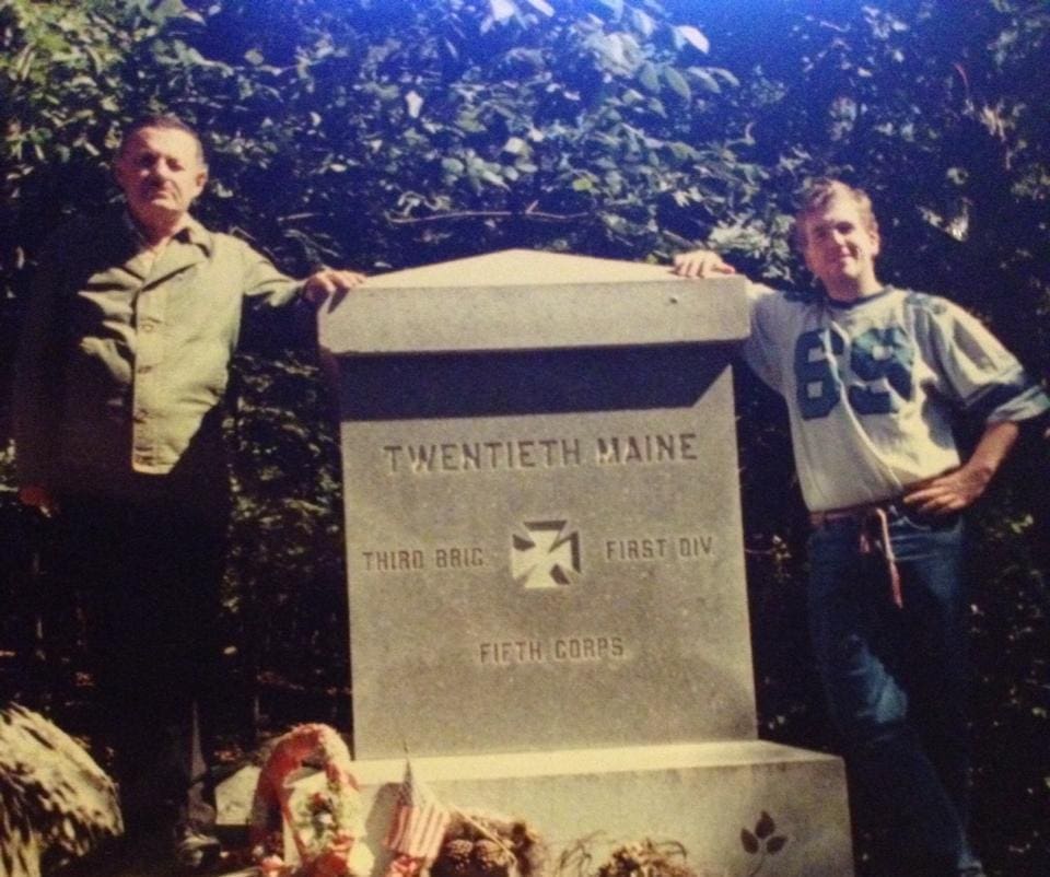 Men standing by Twentieth Maine monument.