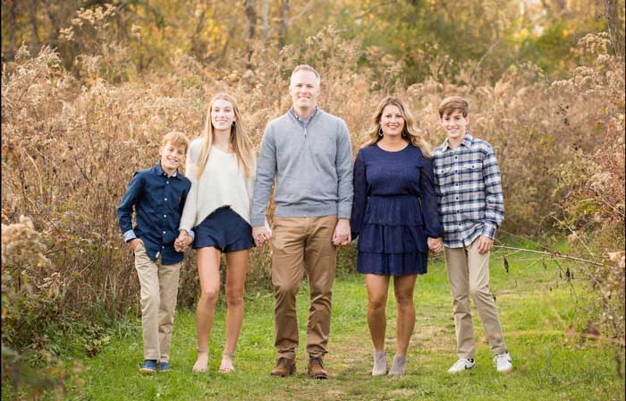 Family portrait in a grassy outdoor setting.