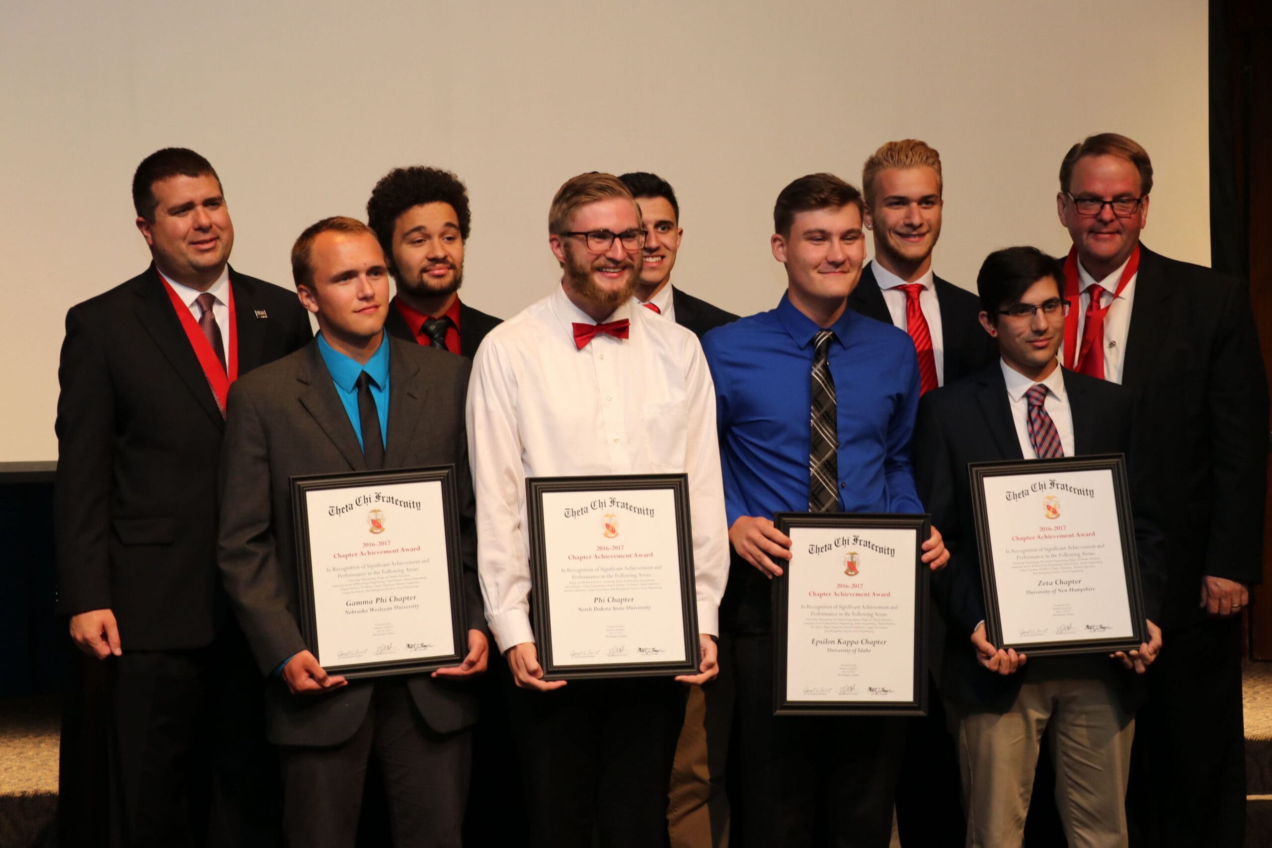 Graduates holding certificates at a recognition ceremony.