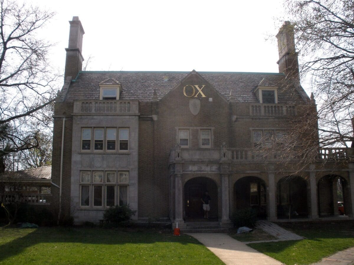 Historic mansion with OX emblem on facade.