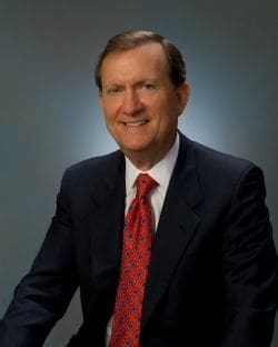 Smiling businessman in a suit with a red tie.