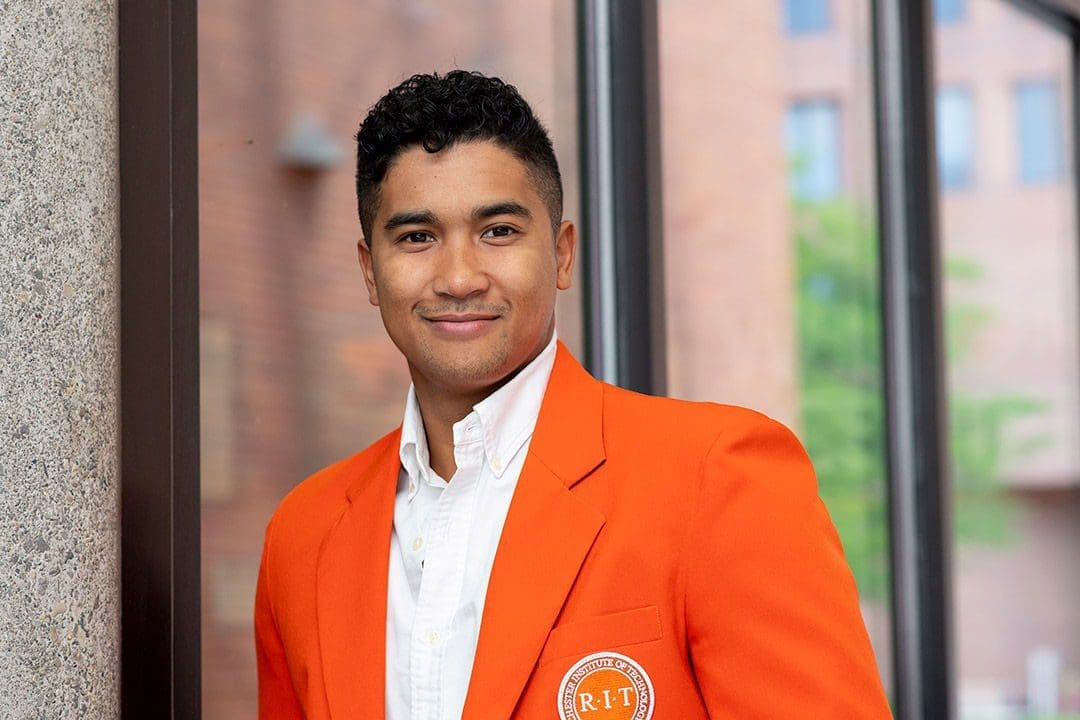 Lucas Randrianarivelo Student in orange blazer at RIT campus.