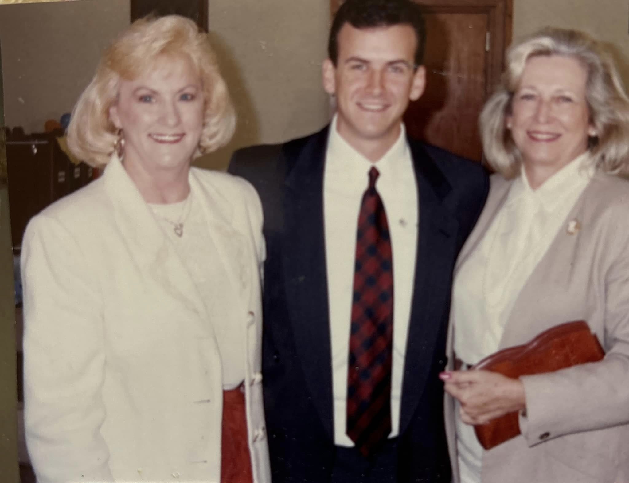 Three people posing together at an event.