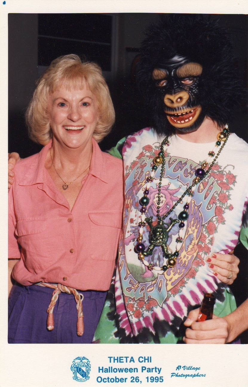 Woman posing with person in gorilla costume.