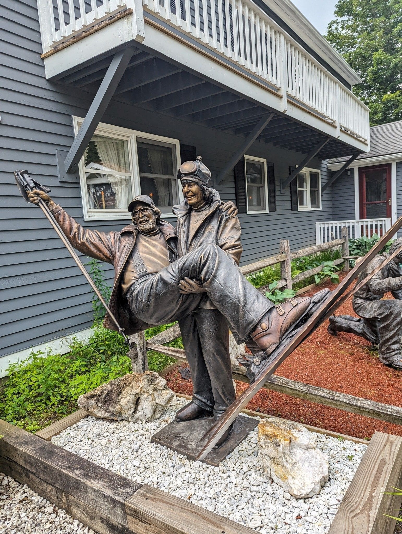 Bronze statue of skiers celebrating together outdoors.