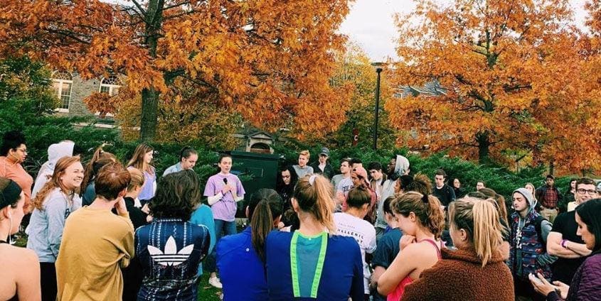 Iota/Colgate Group discussion outdoors with autumn foliage background.
