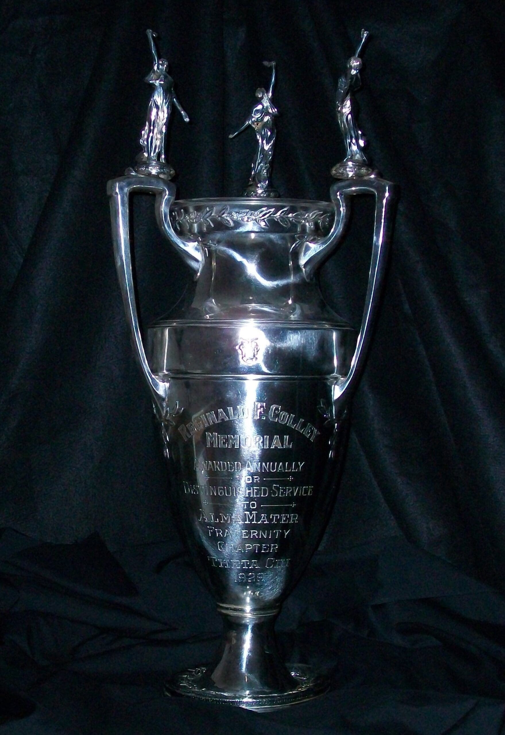 Silver trophy with engraved dedication and ornate handles.