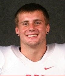 Smiling football player in team uniform portrait.