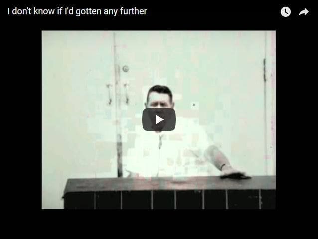 Vintage video still of a man at a door.