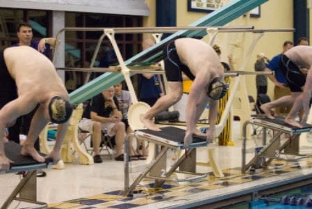 Swimmers preparing to dive at a competition.