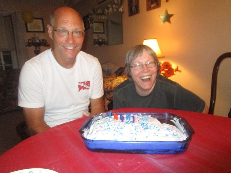 Happy couple celebrating with a decorated cake.