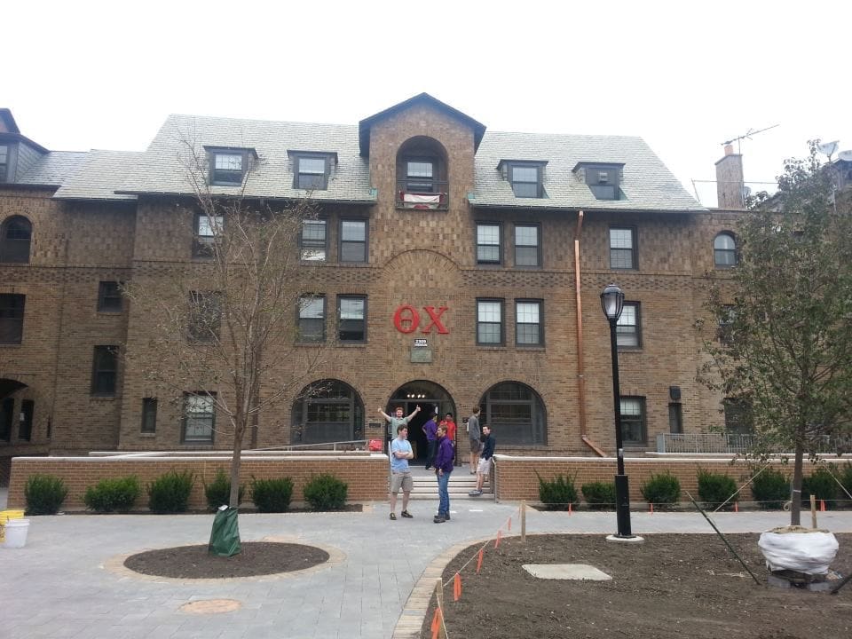 Historic brick building with students in front.