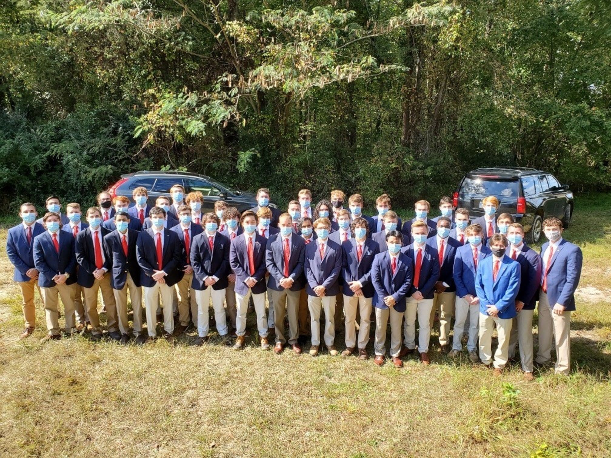 Group of students in masks, outdoors, dressed formally.