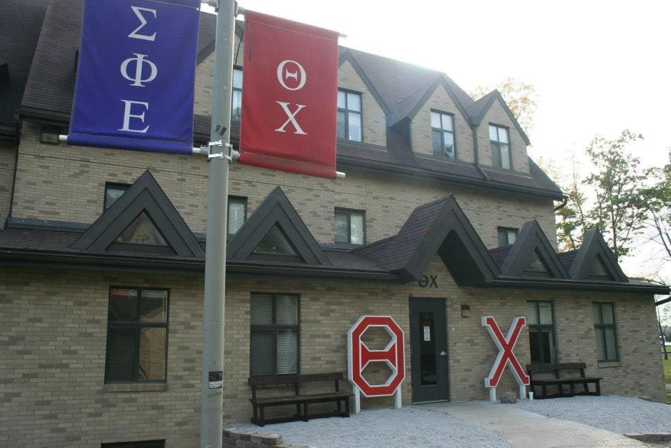 Greek life house with fraternity banners displayed prominently.