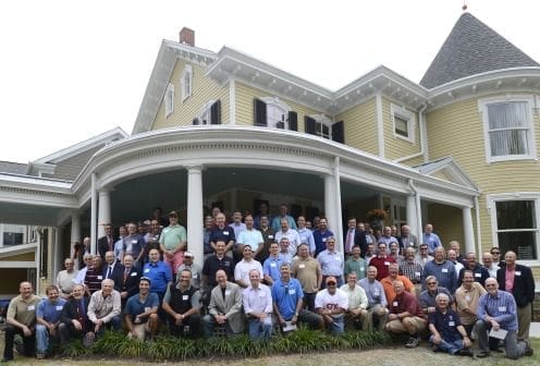 Group photo of men in front of historic house.