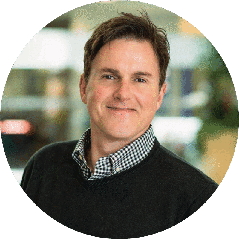Professional portrait of a smiling man in a sweater.