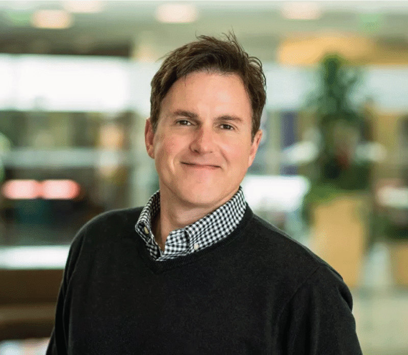 Professional man smiling in modern office setting.