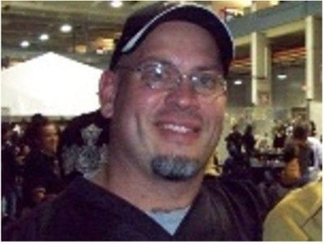 Don Rathmell Smiling man with glasses and a baseball cap.