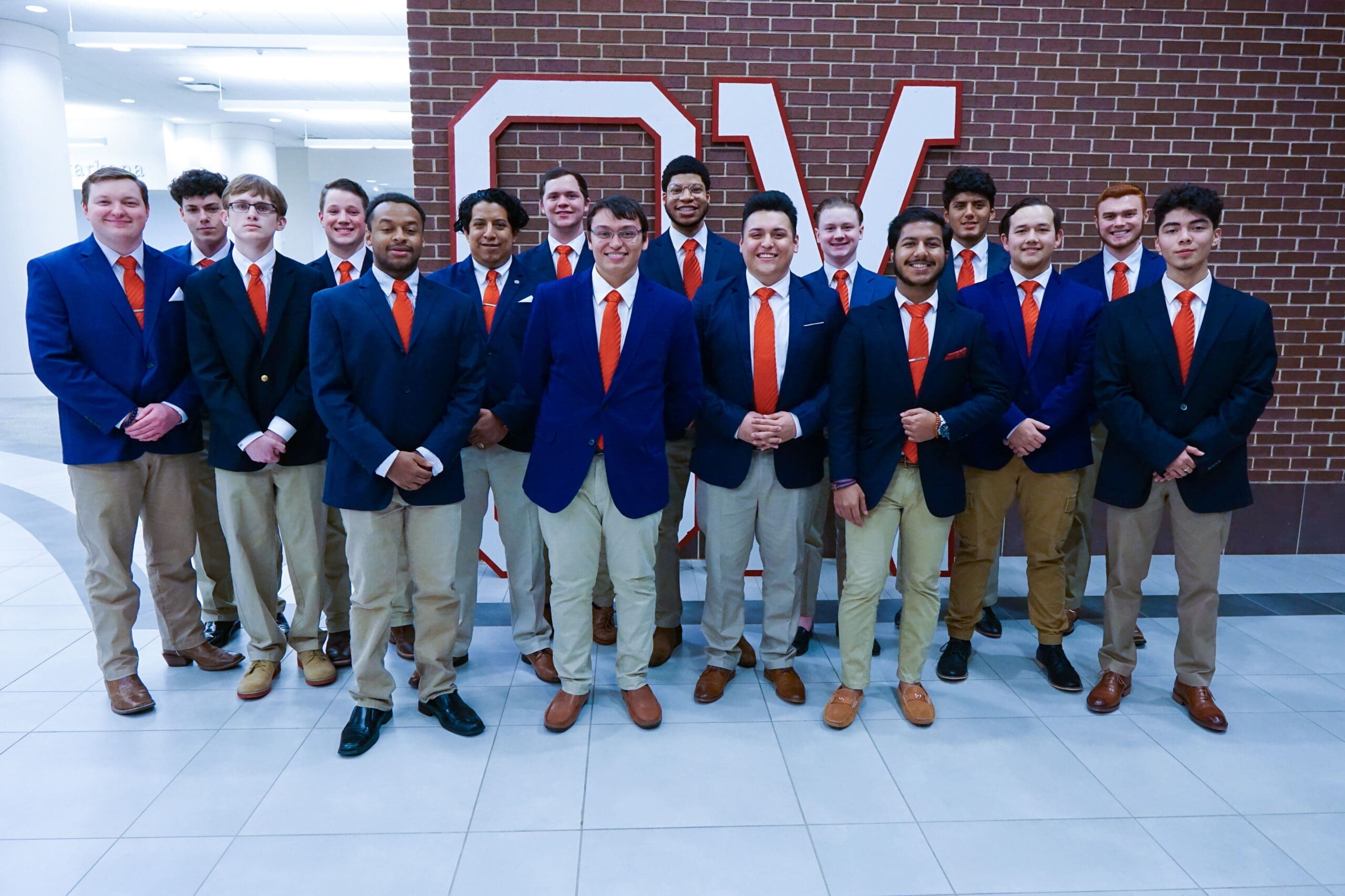 Group of young men in formal attire posing together.