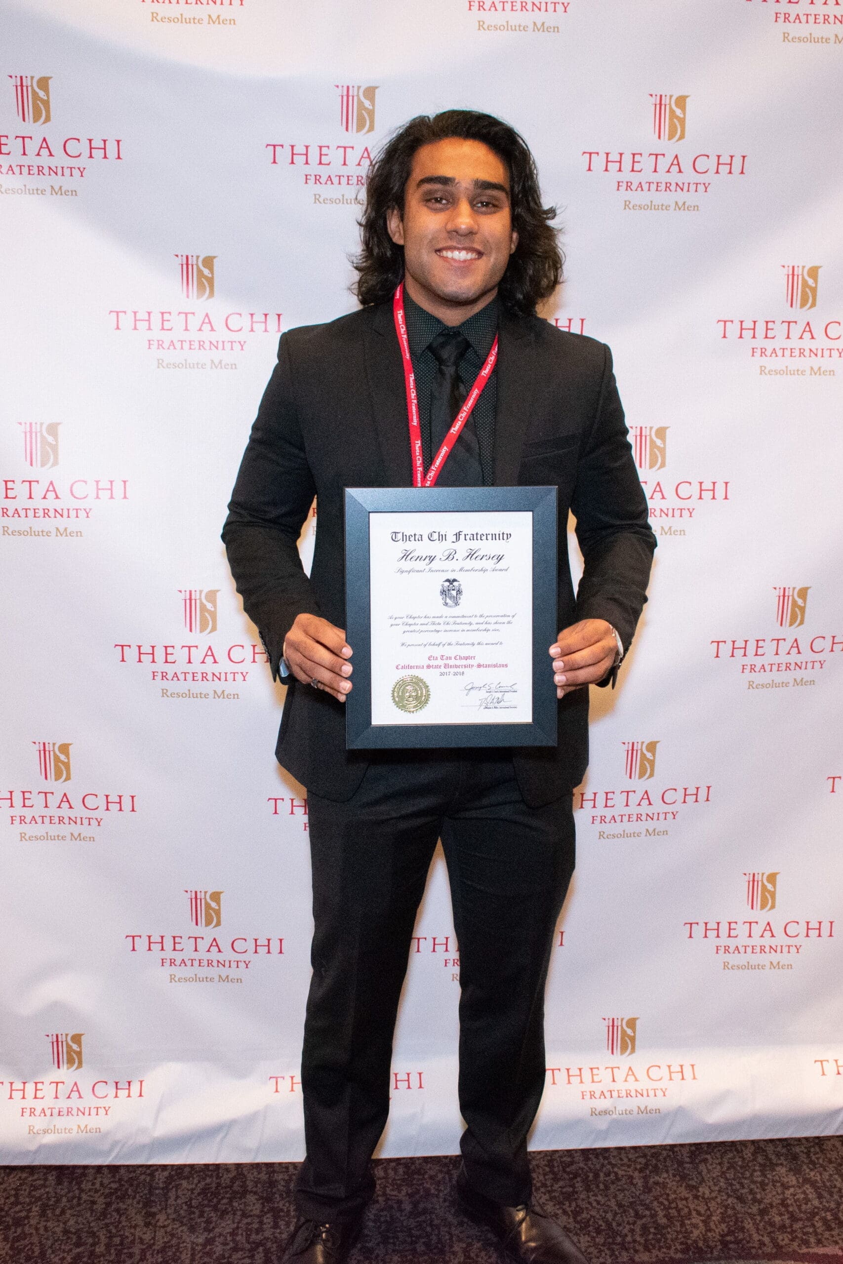 Person receiving award from Theta Chi fraternity.