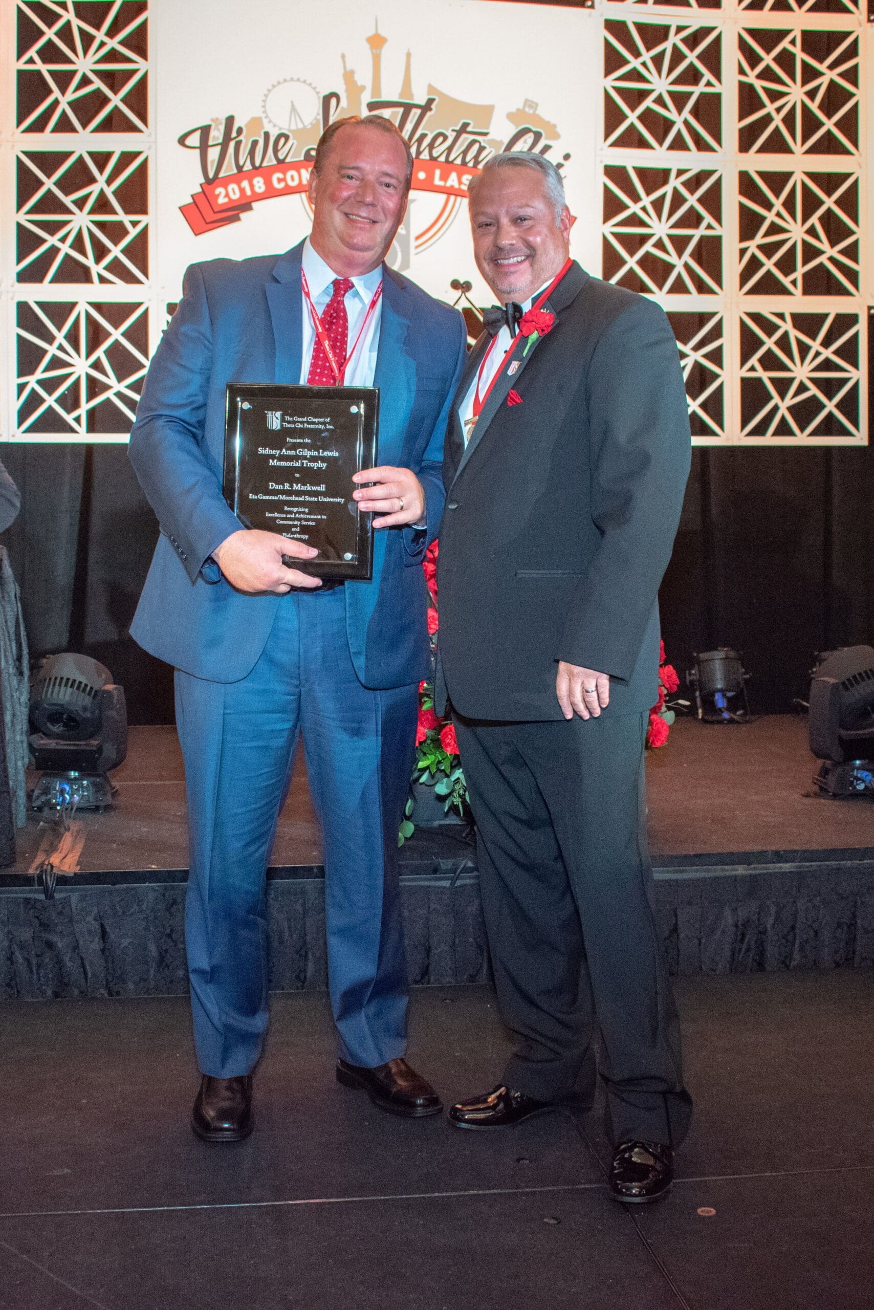 2017/2018 Lewis Award Two men celebrating an award presentation on stage.