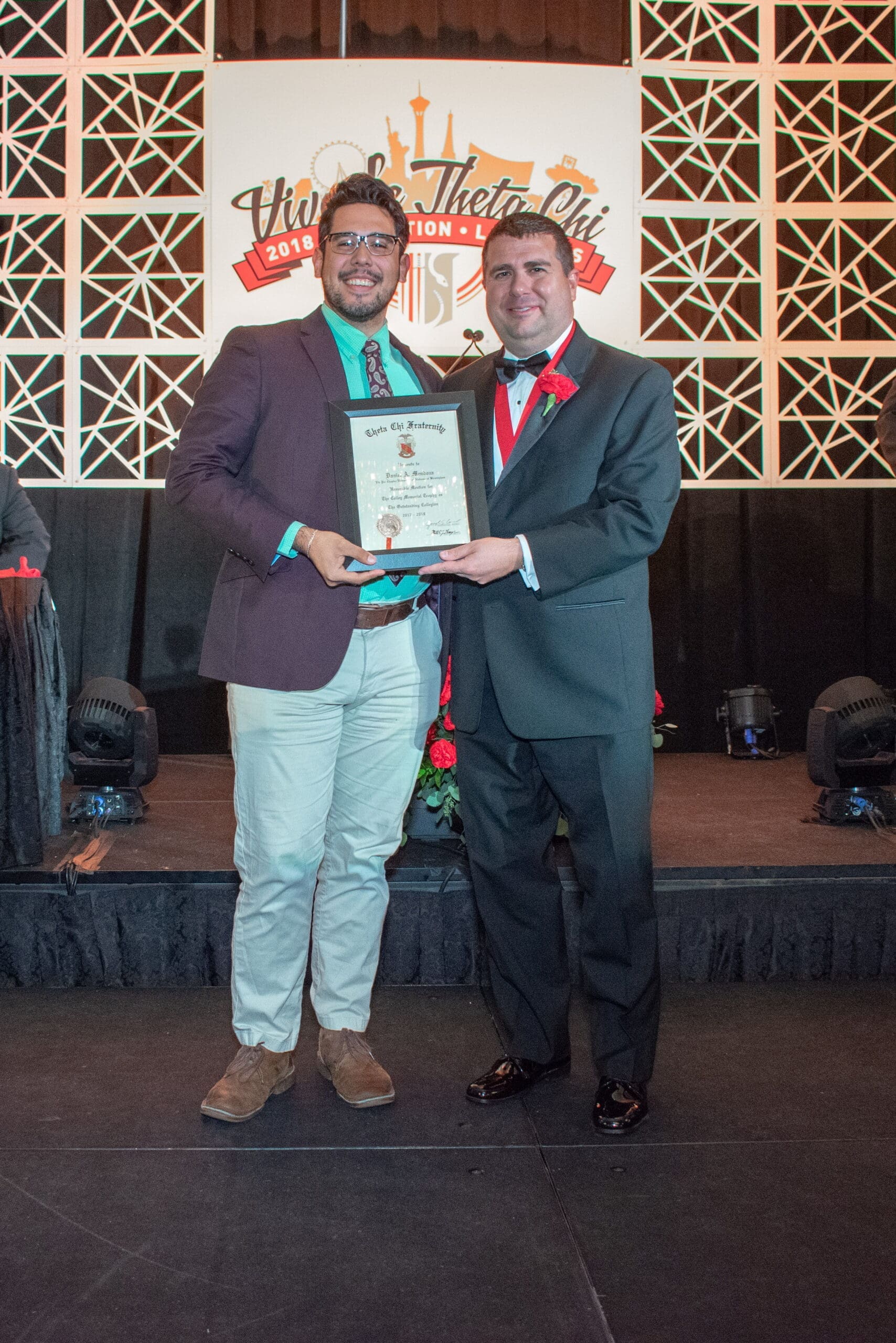 Two men receiving an award at a ceremony.