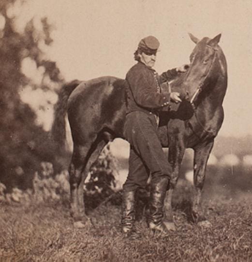 Soldier with horse in historical photograph.