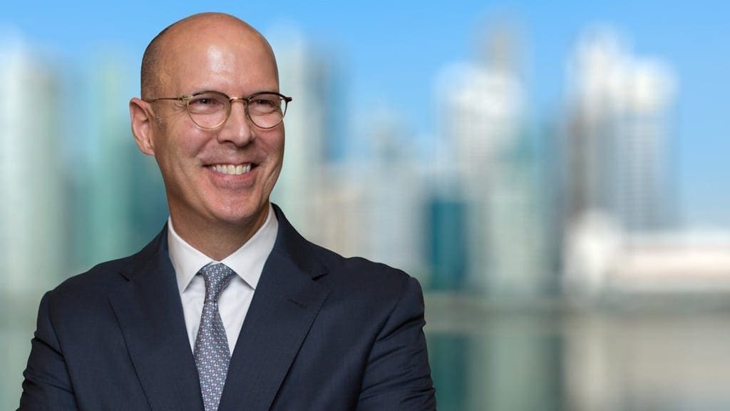 Smiling professional man in business attire with city background.