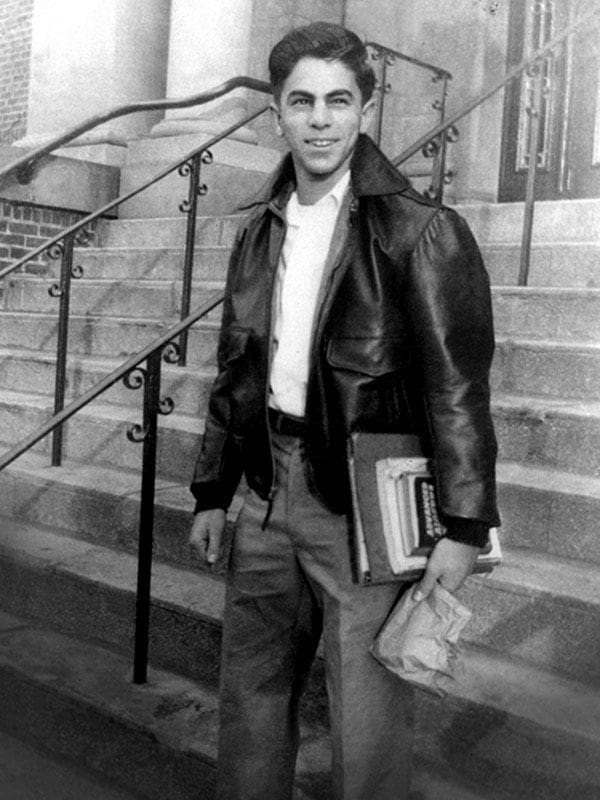 Ed Hajim Young man in leather jacket holding books.