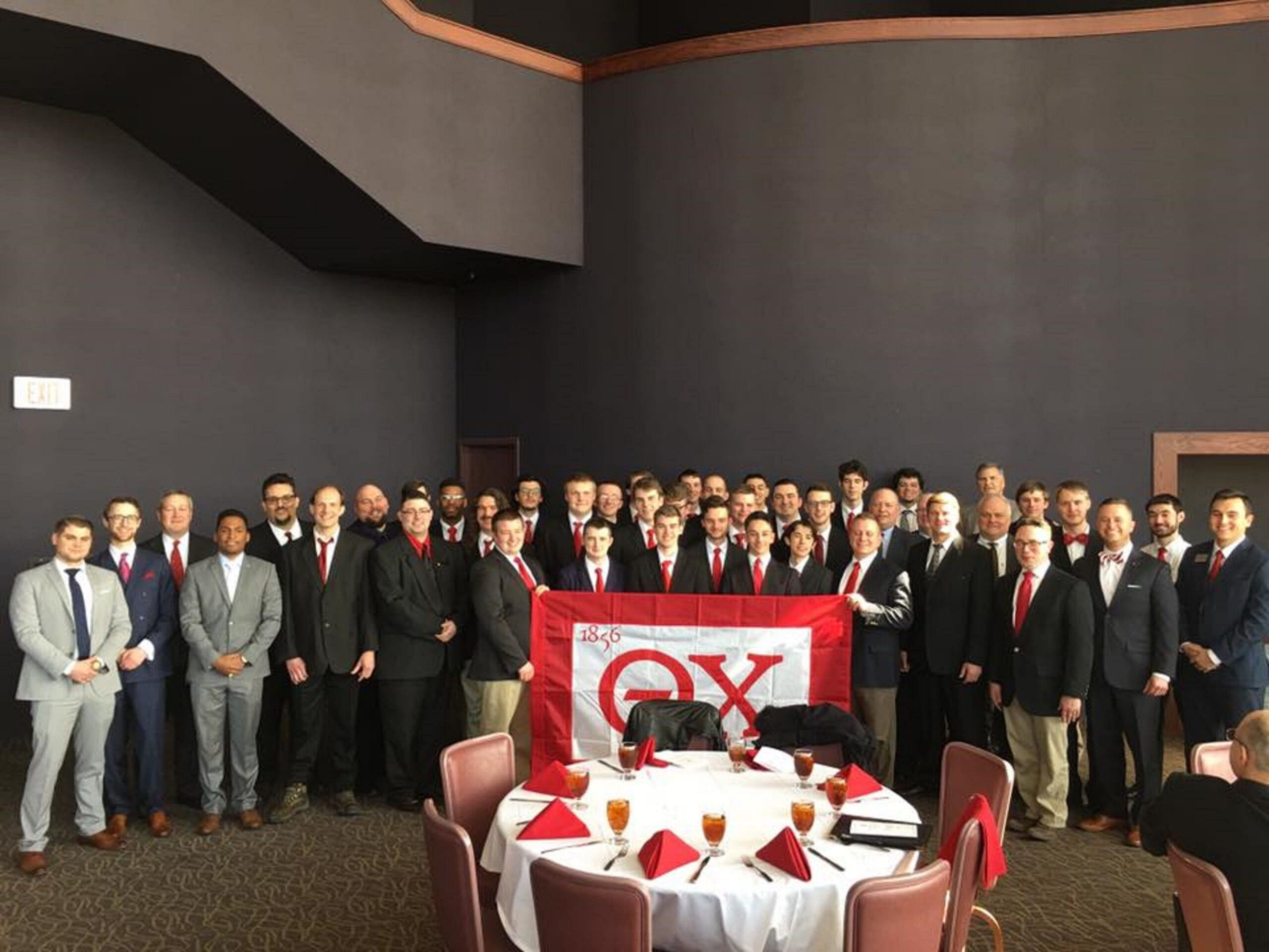 Epsilon Delta Reinstall Group photo of fraternity members with flag.
