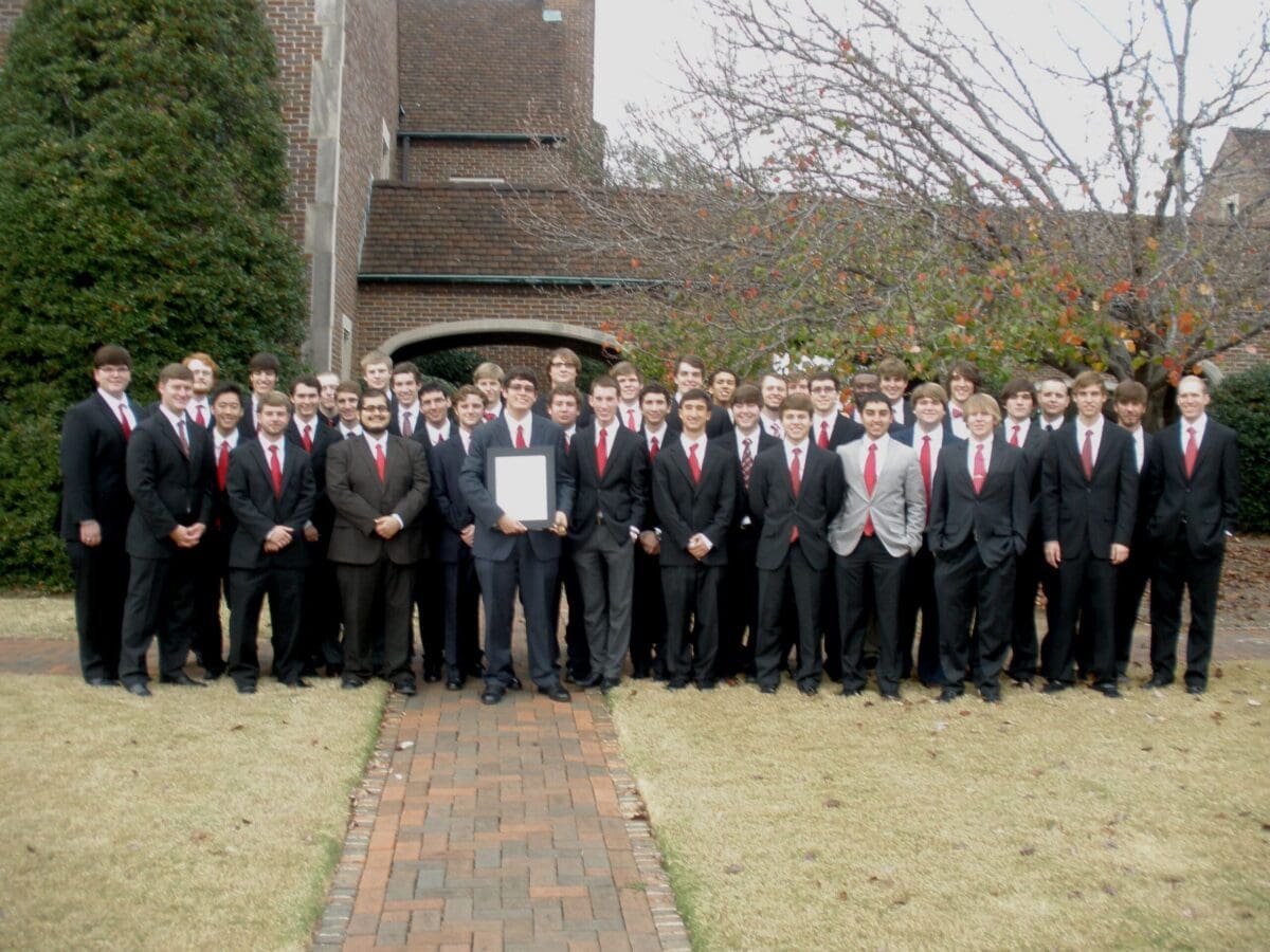 Group of men in suits celebrating an achievement outdoors.