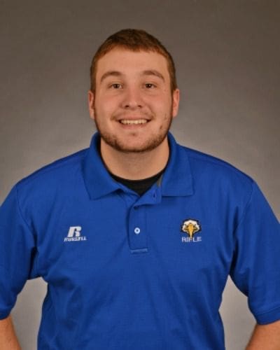 Smiling man in blue polo shirt, professional portrait.