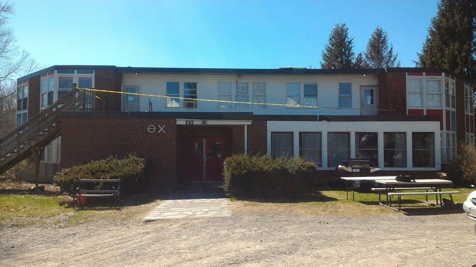 Two-story building with red door and windows.