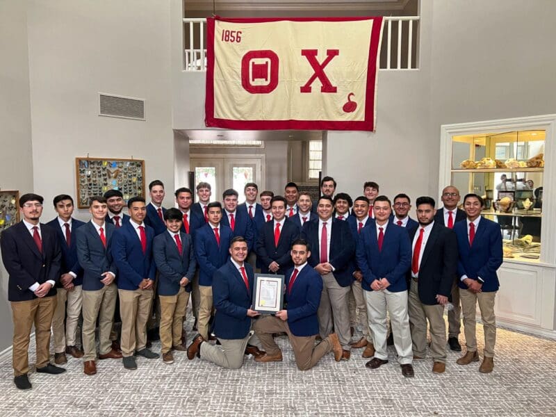 Group of young men in formal attire celebrating achievement.