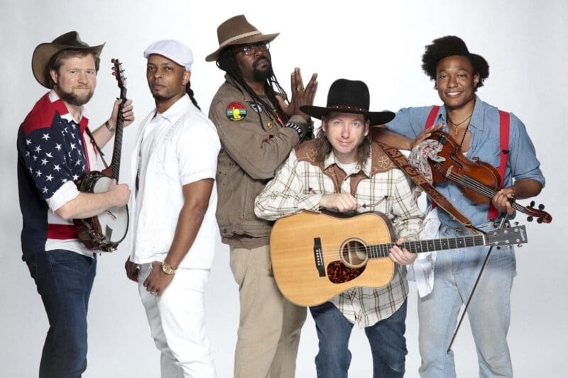Diverse musical group posing with instruments together.