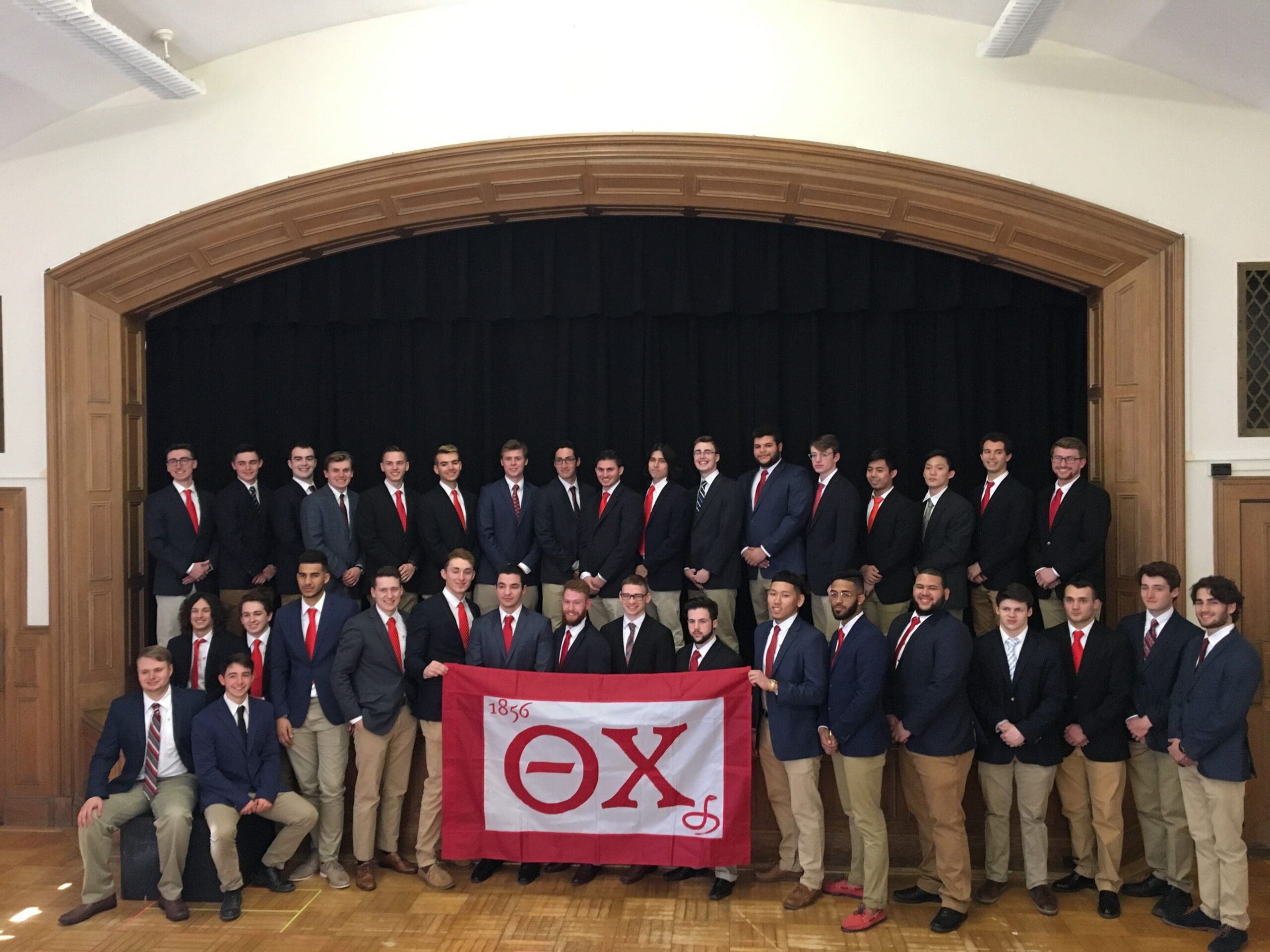 Group photo of fraternity members with banner.