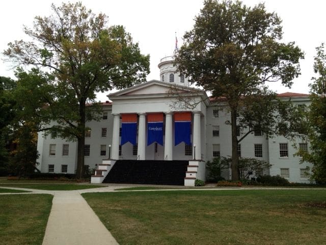 Historic building with columns and colorful banners.