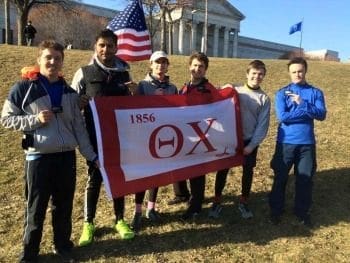 Group of runners holding a flag outdoors.