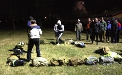 Group of people training outdoors at night.