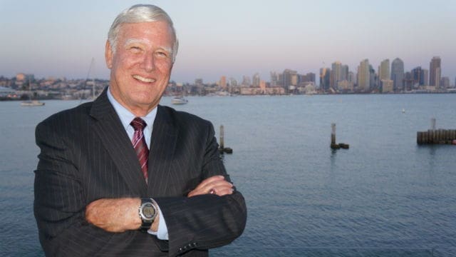 Smiling businessman with city skyline background.