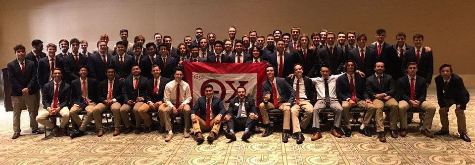 Group photo of fraternity members in formal attire.