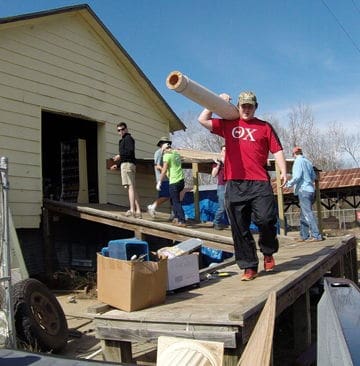 Volunteers carrying supplies during community service project.