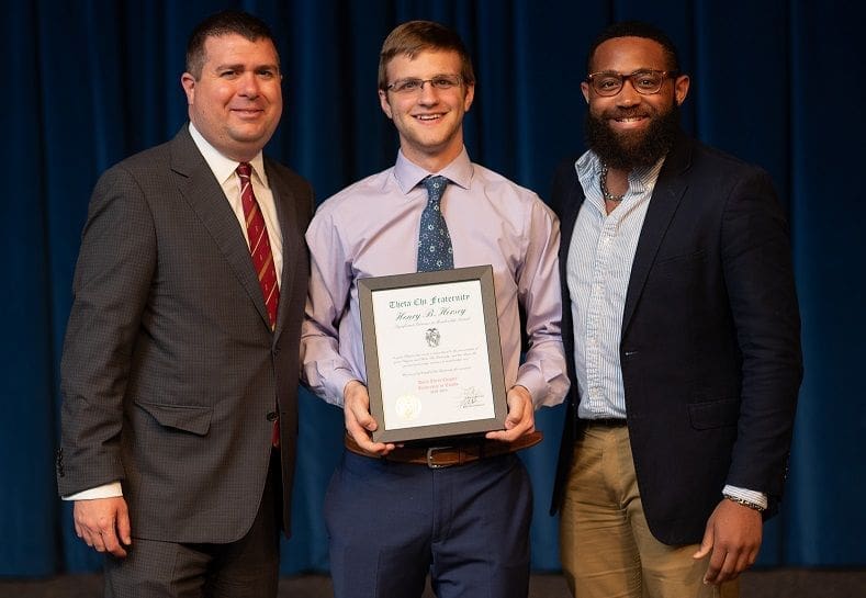 2018/2019 Hersey Award Three men holding an award certificate on stage.