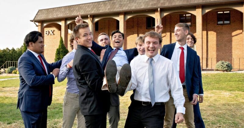 Group of friends celebrating outdoors in formal attire.
