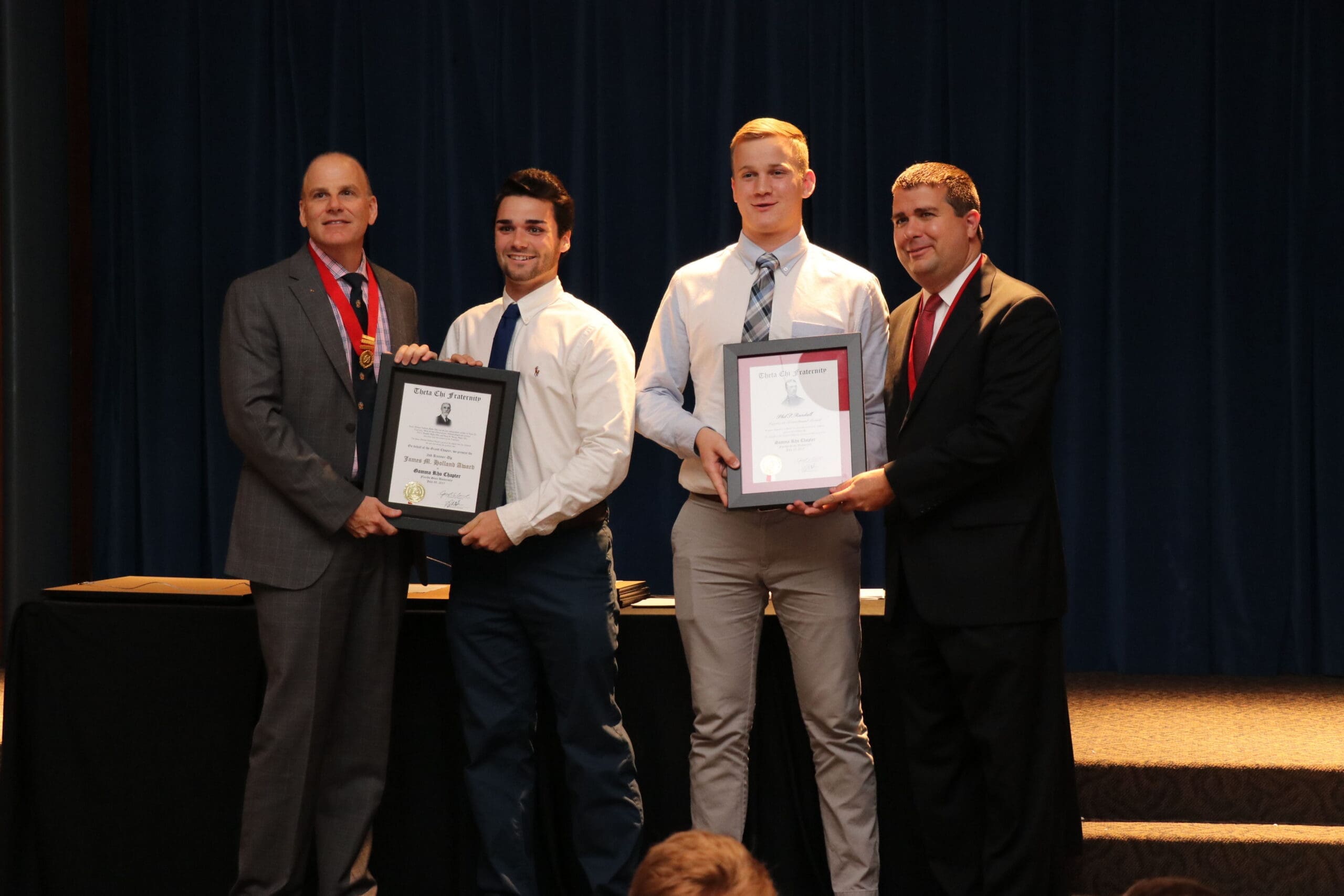Award recipients holding certificates at ceremony.