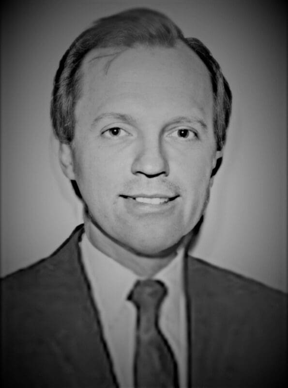 Black and white portrait of a smiling man.